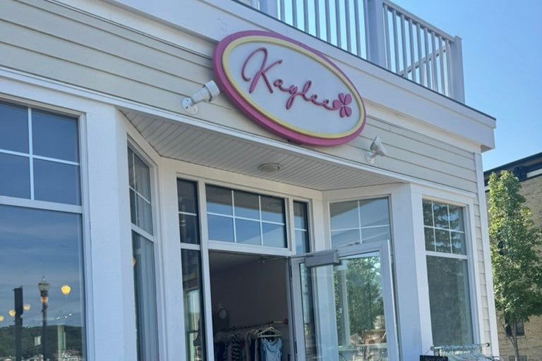 Storefront with 'Kaye & Co.' sign, flowers, and a chalkboard sign outside.